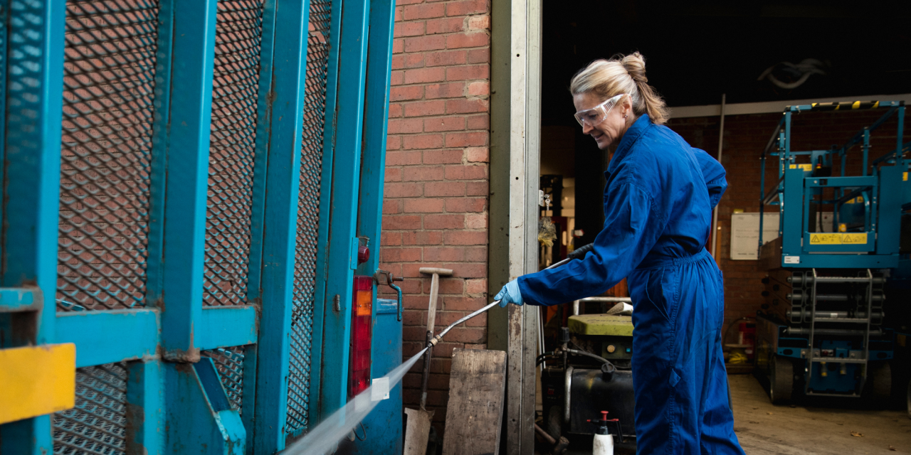 Vrouw is met hoge drukreiniger aan het schoonmaken buiten