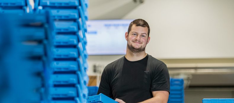 Jongeman aan het werk in het magazijn van een farmaceut.