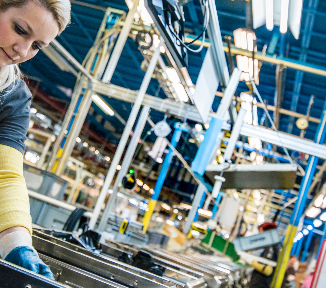 Assemblagemedewerker in een industriële productielijn met machines en lopende banden