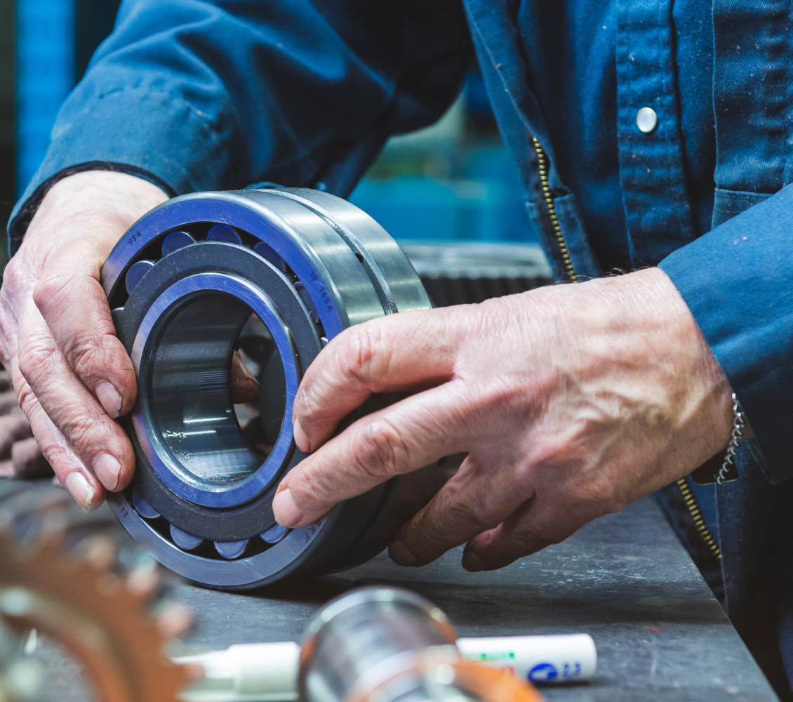 een monteur inspecteert een lagersysteem of metalen mechanisch onderdeel