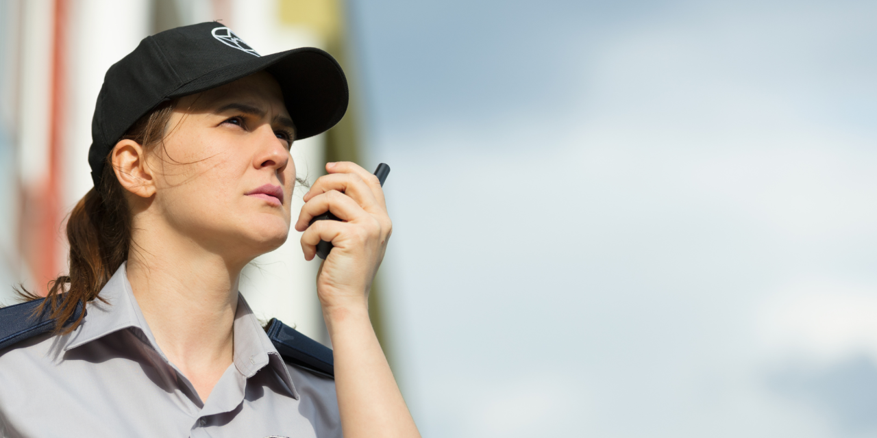 Beveiligingsmedewerker spreekt in portofoon tijdens dienst
