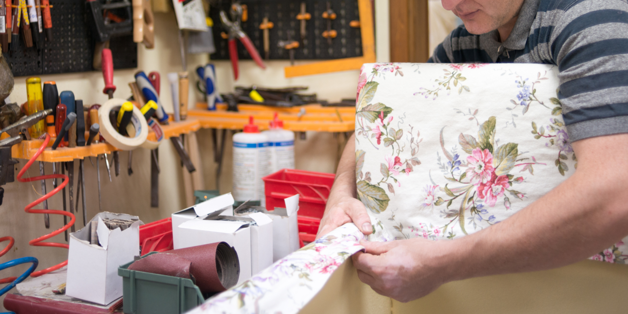 Stoffeerder werkt met meubelstof in atelier
