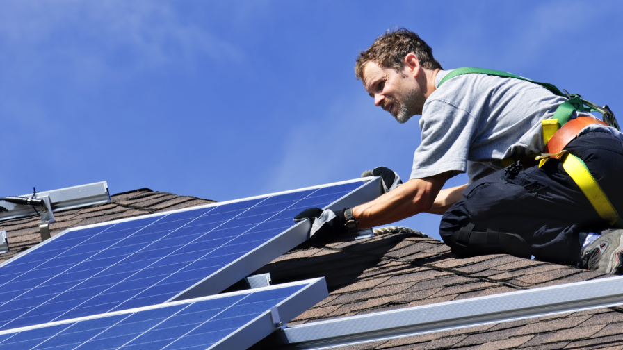 Zonnepanelenmonteur monteert panelen op woning