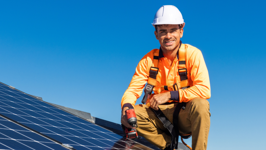 Zonnepanelenmonteur op dak met veiligheidshelm
