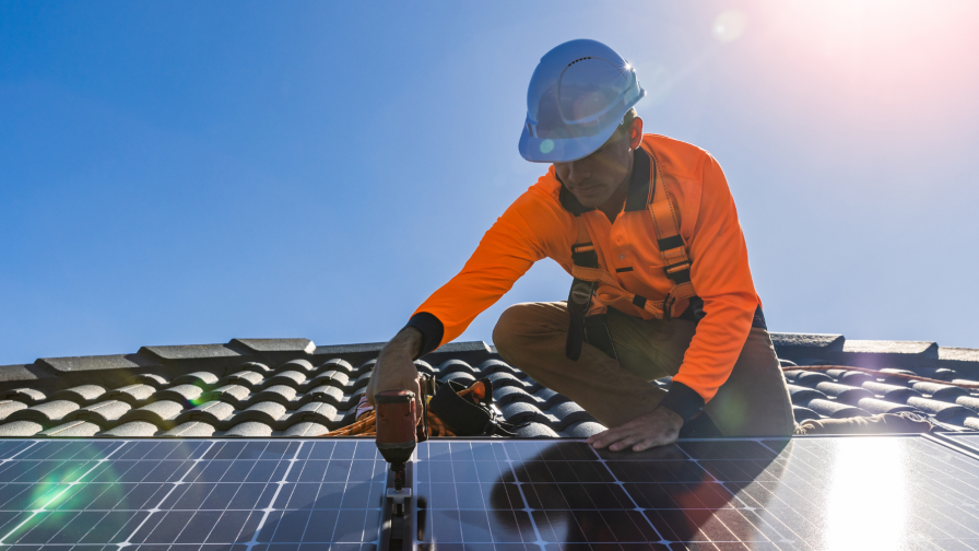 Monteur installeert zonnepanelen op pannendak