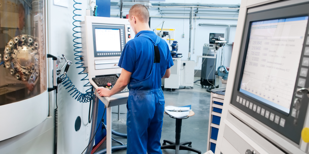 Operator bedient CNC-machine in productieomgeving