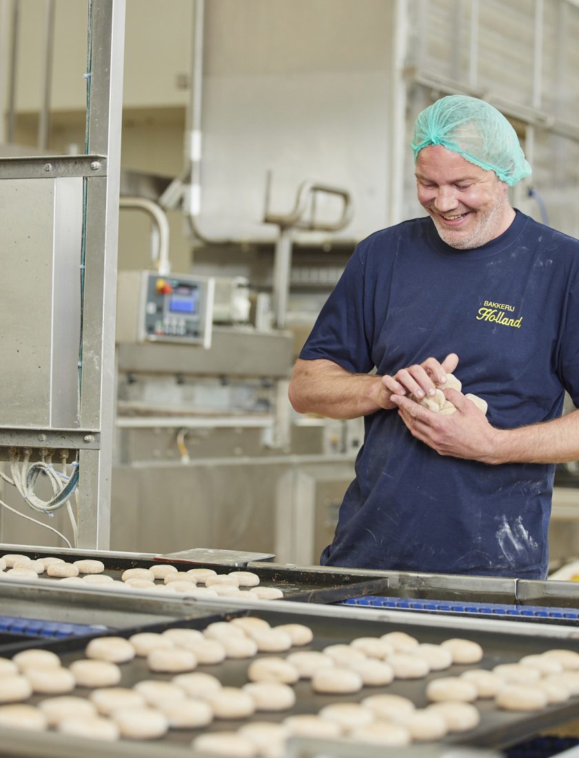 Man staat bij broden als operator te werken in een industriële bakkerij