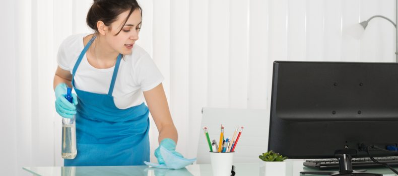 Bureau schoonmaken met schort voor en knotdragend