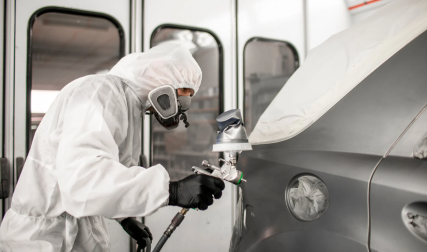 Auto spuiten met beschermende kleding